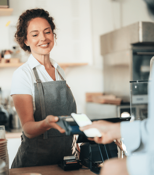 Smiling barista taking contactless payment