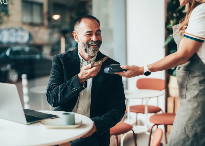 Man paying with smartphone at café