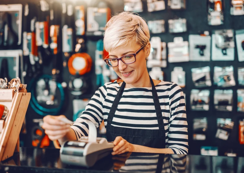 Woman processing payment at checkout counter