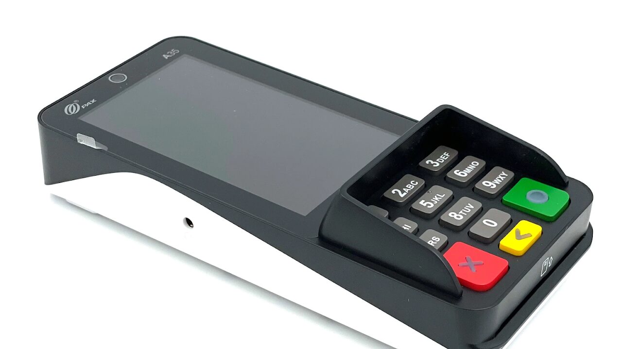 A modern touchscreen payment terminal with a numeric keypad and card slot.