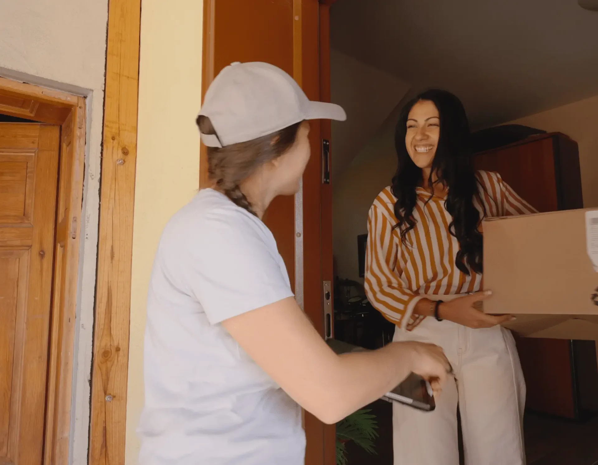 Two friends laughing and chatting at a doorway