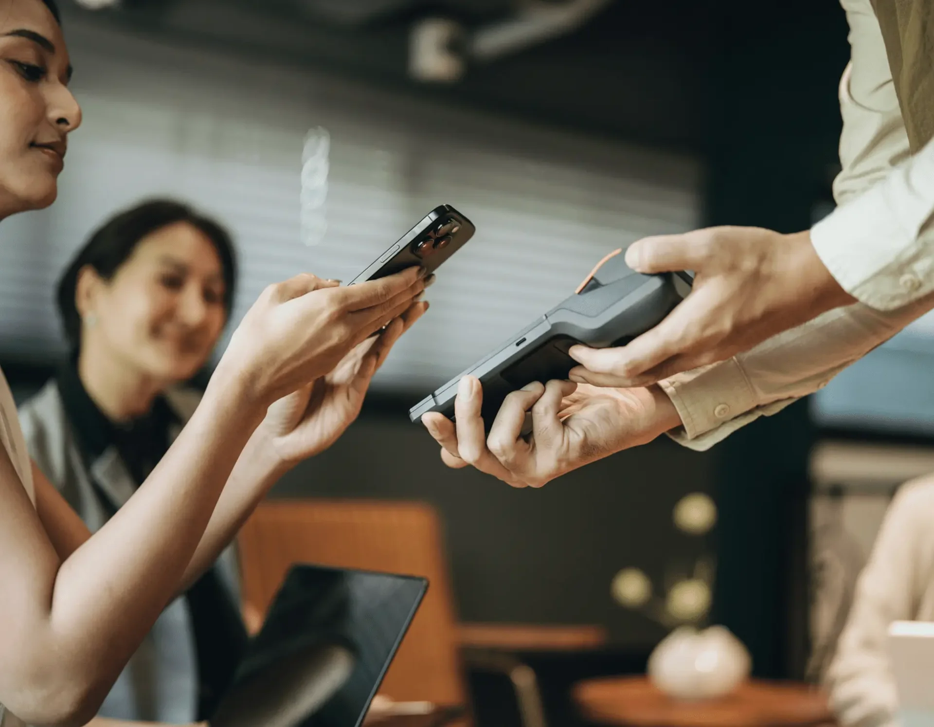A person paying with a credit card using a contactless payment terminal